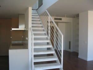 Interior d'apartament modern amb escala minimalista i cuina integrada. Ctra Barcelona 2008.