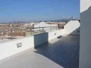 Detall constructiu: terrassa d'àtic amb vistes urbanes i muntanyes