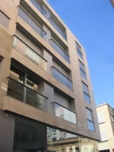 Façana moderna d'edifici residencial amb balcons de vidre. 2008 Ctra Barcelona.