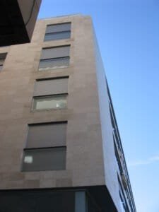 Façana de pedra clara de l'edifici 2008 Ctra Barcelona amb finestres i persianes.