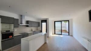 Cuina interior moderna, armaris grisos, illa central, sortida pati cases Palau-Solita.