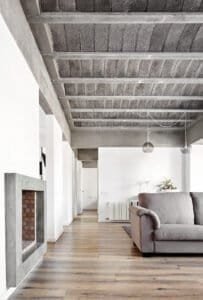 Casa Ullastrell: sala d'estar moderna amb sostre de volta de formigó vist i llar de foc.