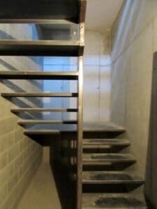 Detall escala metàl·lica i parets de formigó en interior